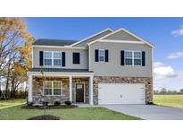 New two-story home featuring gray siding, stone accents, black shutters and a two-car garage at 2573 Summersby Dr, Mebane, NC 27302