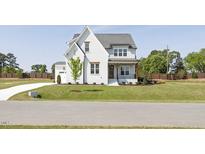 Charming two-story home with a well-manicured lawn and inviting front porch at 3913 Berkeley Town Ln, Fuquay Varina, NC 27526