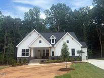 Charming two-story home featuring white siding, stone accents, and a well-manicured front lawn at 60 Valebrook Ct, Youngsville, NC 27596