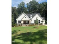 Charming new construction home featuring a landscaped yard, bright white siding, and a welcoming red front door at 60 Valebrook Ct, Youngsville, NC 27596