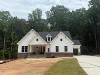 Beautiful two-story home with white siding, stone accents, and a lush green lawn at 60 Valebrook Ct, Youngsville, NC 27596