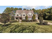 Traditional home with mature landscaping, a well-manicured lawn, and a welcoming front porch at 690 Hawthorne Pl, Creedmoor, NC 27522