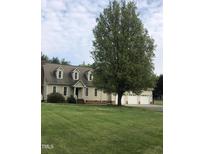 Charming home featuring a spacious front yard, large shade tree, and an attached three-car garage at 8510 Polaris Dr, Bahama, NC 27503