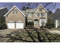 Charming brick home featuring an attached two-car garage and manicured landscaping at 9244 Palm Bay Cir, Raleigh, NC 27617
