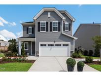 Charming two-story home featuring a two-car garage and traditional curb appeal with gray siding and black shutters at 1124 Topaz Cave Cir, Raleigh, NC 27610
