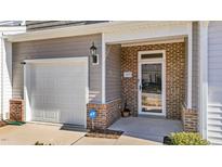 Inviting front door with brick detail, garage, and security system at 123 Liam St, Clayton, NC 27520