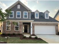 Beautiful two-story home featuring a brick and siding exterior, attached two car garage and landscaped front yard at 124 Willow Cameron Way, Angier, NC 27501