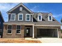 New construction home with brick and gray siding, showcasing a modern two-story design and attached garage at 124 Willow Cameron Way, Angier, NC 27501
