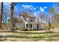 Charming white two-story home with a full front porch and mature trees in a large yard at 12808 Old Stage Rd, Willow Springs, NC 27592