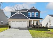 Charming two-story home featuring a two-car garage, manicured lawn, and craftsman-style details at 212 Wildwood Ln, Graham, NC 27253