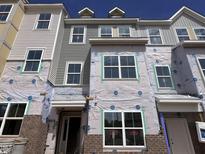 A new multi-story home under construction with brick and siding, showcasing multiple windows at 328 Chesapeak Commons St # 142, Garner, NC 27529