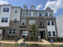 New two-story townhome featuring brick and siding facade, complemented by professionally landscaped front yard at 328 Chesapeak Commons St # 142, Garner, NC 27529