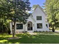 Charming two-story home with white brick, black trim, landscaped yard and a beautiful lawn at 3513 Eden Croft Dr, Raleigh, NC 27612