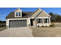 Charming tan home with a gray garage door, dormer window, and a well-manicured lawn at 39 Flatland Dr, Princeton, NC 27569