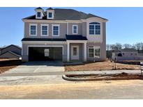 Charming two-story home features a two-car garage, well-manicured lawn, and classic architectural details at 4302 Emeline Way # 16, Fuquay Varina, NC 27526