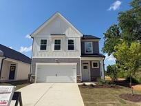 Charming two-story home with a two-car garage and classic curb appeal on a sunny day at 82 Fairwinds Dr, Lillington, NC 27546