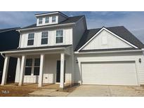 Charming two-story home with white siding, covered porch, and attached two car garage at 106 Willow Cameron Way, Angier, NC 27501
