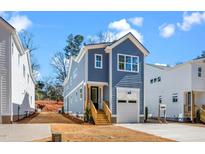 Charming blue two-story home with a garage and a wooden staircase leading to the front entrance at 1211 Chaney Rd, Raleigh, NC 27606