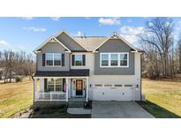 Charming two-story home with a covered porch, white trim, and a two-car garage at 1318 Reading Ct, Burlington, NC 27217