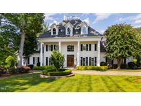Stately brick home with manicured lawn, mature trees, and stately white pillars at 1416 Barony Lake Way, Raleigh, NC 27614