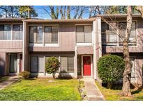 Inviting townhome showcasing a red front door, manicured shrubs and healthy green lawn at 1738 Quail Ridge Rd, Raleigh, NC 27609