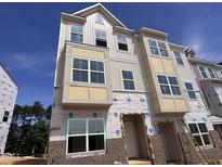 New construction two-story home featuring modern design, large windows, and a brick foundation, enhancing its curb appeal at 336 Chesapeak Commons St # 140, Garner, NC 27529
