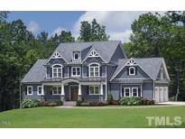 Beautiful two-story home with stylish blue siding, gabled roof, and a well-manicured front lawn at 405 Fieldstone Ln, Pittsboro, NC 27312