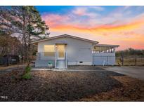 Charming one-story home featuring a covered porch and a partially screened patio addition at 409 S 13Th St, Lillington, NC 27546