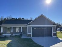 Charming single-story home featuring a two-car garage and manicured lawn on a sunny day at 42 Heatherglenn Cir, Princeton, NC 27569