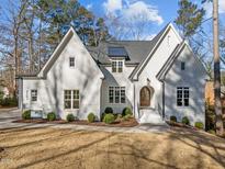 Stunning white brick home featuring a well-manicured lawn and professionally landscaped shrubbery at 4501 Bartlett Dr, Raleigh, NC 27609