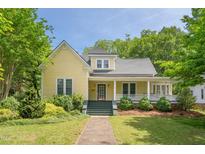 Charming yellow home featuring a welcoming front porch and well-maintained landscaping at 531 N Main St, Graham, NC 27253