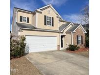 Charming two-story home boasts a two car garage, neutral siding and black shutters against a blue sky at 6013 Shelane Ct, Raleigh, NC 27610