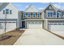 A welcoming exterior view showing a modern townhome with an attached two-car garage and concrete driveway at 624 Brittany Ct, Durham, NC 27703