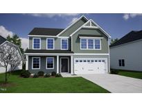 Charming two-story home with a two-car garage, nicely landscaped yard, and beautiful curb appeal at 108 Grove Township Way, Angier, NC 27501