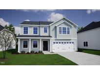 Charming two-story home with a covered porch and a two-car garage at 119 Grove Township Way, Angier, NC 27501