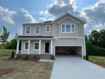 Charming new two-story home featuring a spacious garage and well-manicured lawn at 119 Grove Township Way, Angier, NC 27501