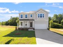 Charming two-story home with a well-manicured lawn and a classic facade under a bright blue sky at 119 Grove Township Way, Angier, NC 27501