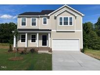 Charming two-story home features a two-car garage, black front door, and a well-manicured lawn at 119 Grove Township Way, Angier, NC 27501