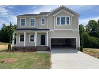 Charming two-story home featuring a large two car garage and a well manicured lawn at 119 Grove Township Way, Angier, NC 27501