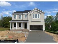 Two-story home with a two-car garage and a freshly poured concrete driveway at 119 Grove Township Way, Angier, NC 27501