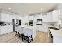 Bright eat-in kitchen boasts an island with seating, stainless appliances, and white cabinets at 130 Silent Brook Trl, Franklinton, NC 27525
