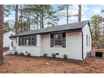 Charming white brick home with black shutters and a well-maintained lawn and mature trees at 1804 Beverly Rd, Rocky Mount, NC 27801