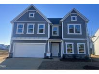 Charming two-story home featuring a two-car garage, stone accents, and a well-maintained front yard at 185 Horseshoe Pl # 54, Angier, NC 27501