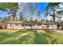 Charming single-story home with a well-manicured lawn and mature trees offering curb appeal at 210 S General Lee Ave, Dunn, NC 28334