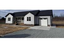 Charming single-story home features gray siding, a dark roof, a welcoming porch, and an attached single-car garage at 211 Mattress Factory Rd, Mebane, NC 27302