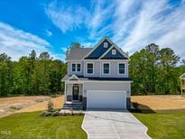Charming two-story home boasts a well-manicured lawn, two car garage, and inviting curb appeal at 394 Duncan Creek Rd # 158, Lillington, NC 27546