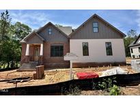 New construction home with brick and siding exterior, featuring a welcoming front porch and professional landscaping at 55 Cherry Bark Dr, Youngsville, NC 27596