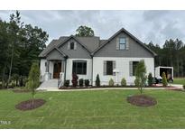 Charming single Gathering home with a landscaped front yard and a combination of brick and clapboard siding at 55 Cherry Bark Dr, Youngsville, NC 27596
