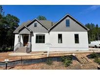 Charming home with a combination of painted brick and vinyl siding, set against a backdrop of lush greenery at 55 Cherry Bark Dr, Youngsville, NC 27596