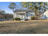 Charming single-story home featuring a well-maintained lawn, classic architecture, and mature trees at 701 E Mason St, Franklinton, NC 27525